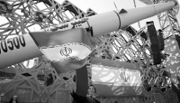 Une Iranienne brandit un drapeau national à côté d'une maquette du missile balistique iranien Kheibar Shekan à Téhéran, le 4 juin 2026.