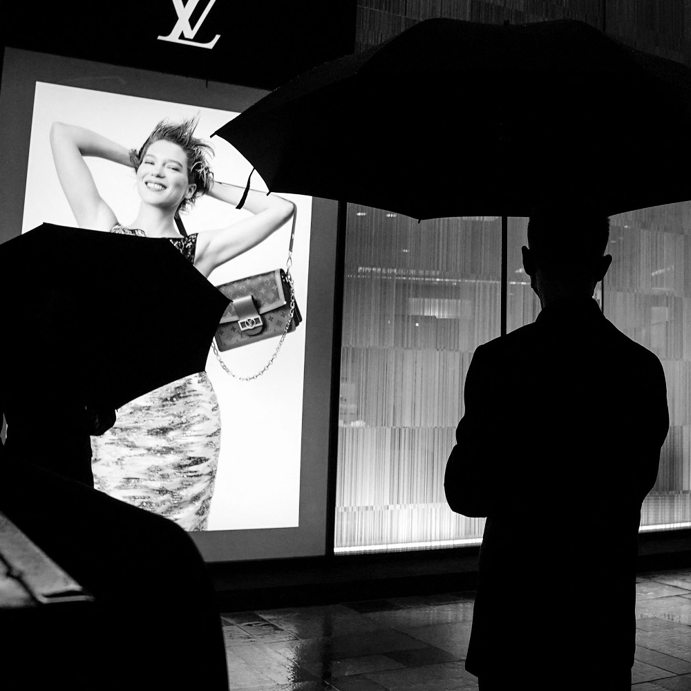 Un agent de sécurité devant un magasin Louis Vuitton.