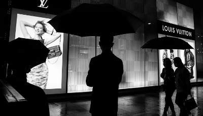 Un agent de sécurité devant un magasin Louis Vuitton.