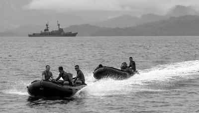 Marins philippins devant le patrouilleur hauturier Andres Bonifacio ancré dans la baie d'Ulugan, à Puerto Princesa, à l'ouest de Manille, le 8 juin 2025.