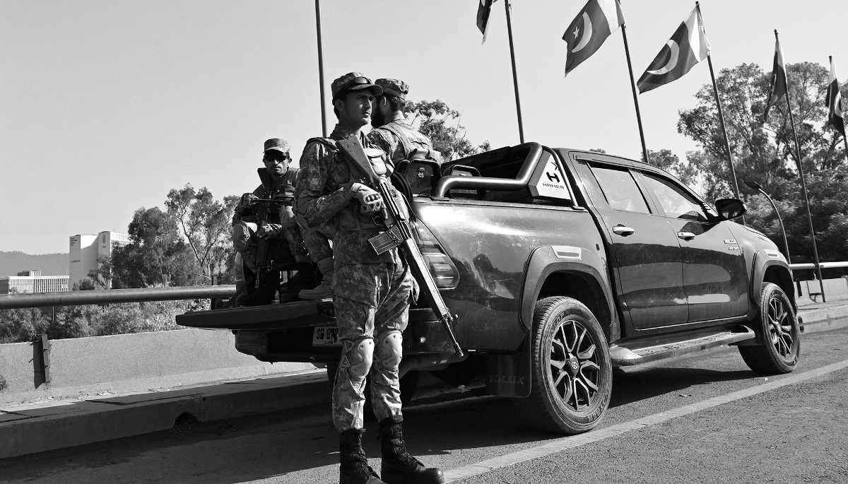 Des militaires pakistanais surveillent une route fermée dans la zone rouge d'Islamabad où se tiennent les négociations de paix entre les États-Unis et l'Iran, le 25 avril 2026.