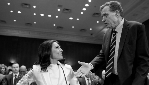 Tulsi Gabbard, la candidate du président Trump au poste de directeur du renseignement national, et le sénateur américain Mark Warner lors de l'audience de confirmation de la commission du renseignement du Sénat au Capitole à Washington, le 30 janvier 2025. 