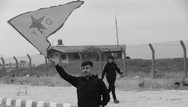 Un Kurde syrien brandit le drapeau des YPG près de l'aéroport de Qamishli, dans le nord-est de la Syrie, le 8 décembre 2024.