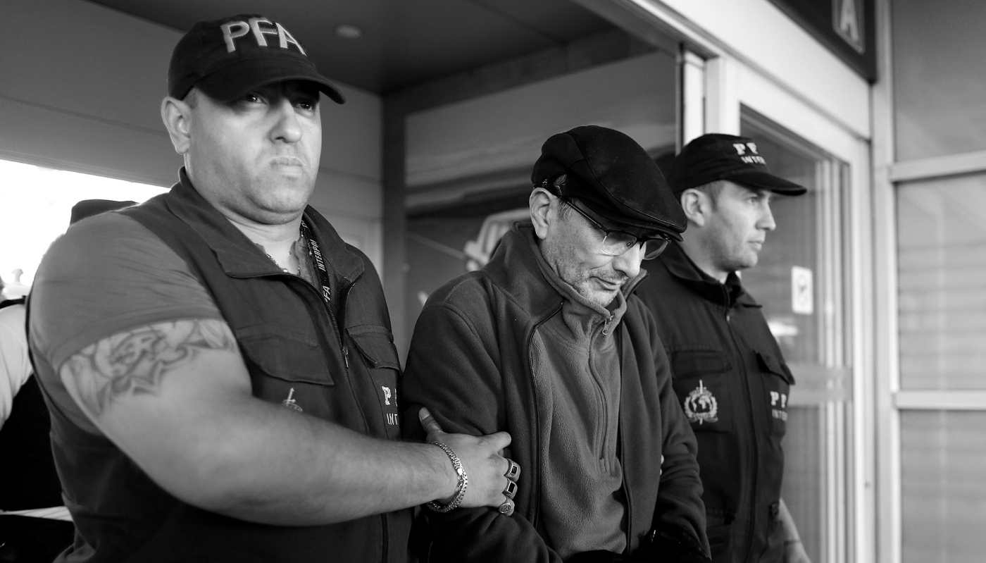 Mario Sandoval, un ex-policier argentin accusé de crimes contre l'humanité commis en Argentine, est escorté par des policiers à l'aéroport international Ministro Pistarini après avoir été extradé de France, à Buenos Aires, le 16 décembre 2019.