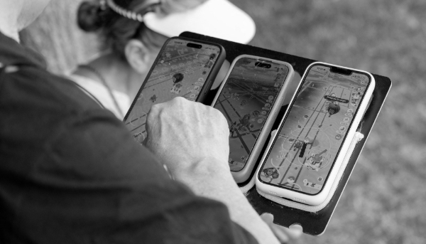 Un fan joue à Pokémon Go sur trois smartphones, lors de la journée d'ouverture du Pokémon Go Fest 2025, au Parc de Sceaux, au sud de Paris, le 13 juin 2025.