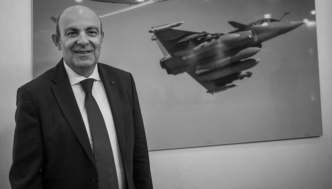 Éric Trappier, PDG du groupe Dassault Aviation, pose à côté d'une affiche représentant un avion de chasse Rafale, le 4 mars 2022.