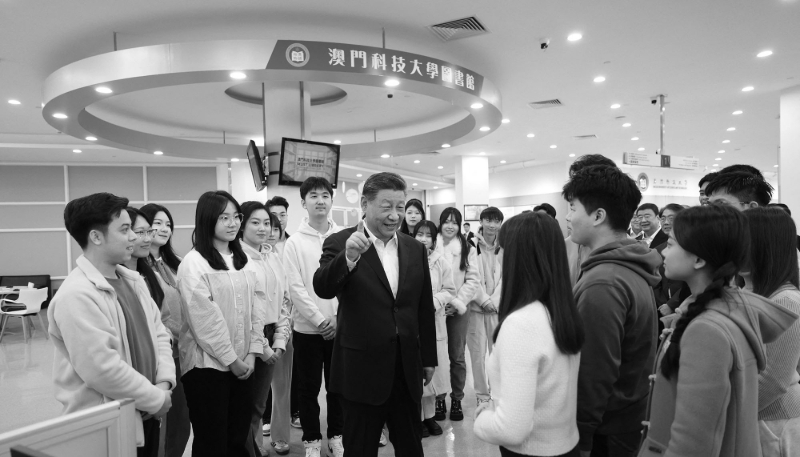 Le président chinois Xi Jinping s'entretient avec des étudiants dans la bibliothèque de l'Université des sciences et technologies de Macao (MUST), dans le sud de la Chine, le 19 décembre 2024. 