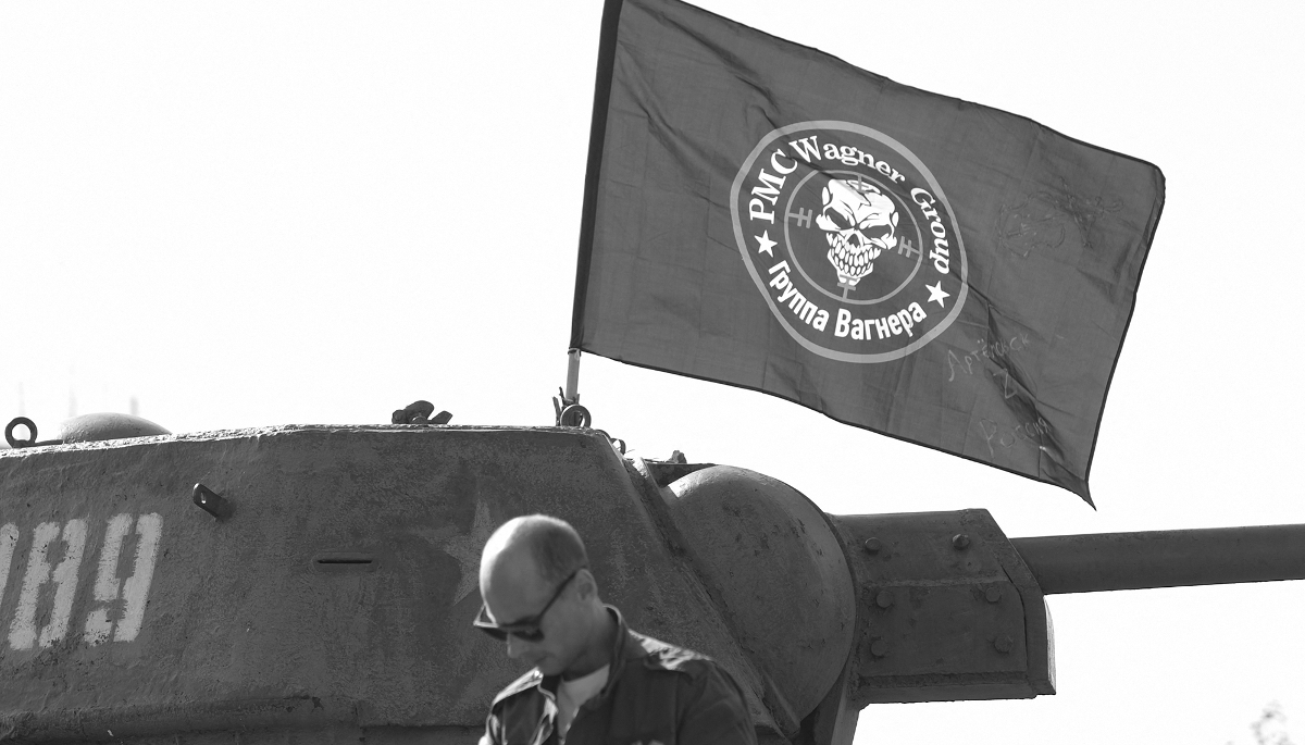 Un homme se trouve devant un drapeau à l'effigie du groupe Wagner hissé sur un vieux tank dans un parc de Donetsk, dans la région ukrainienne du Donbass contrôlée par la Russie, le 1er octobre 2023.