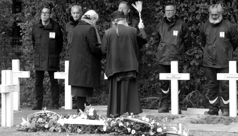Un prêtre orthodoxe bénit les croix qui ornent les tombes de trois soldats russes de la Première Guerre mondiale, au cimetière national de Saint-Hilaire-le-Grand, dans le nord de la France, le 27 octobre 2023, après leur découverte l'année dernière à Courcy.