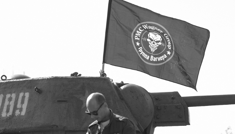 Un homme se trouve devant un drapeau à l'effigie du groupe Wagner hissé sur un vieux tank dans un parc de Donetsk, dans la région ukrainienne du Donbass contrôlée par la Russie, le 1er octobre 2023.