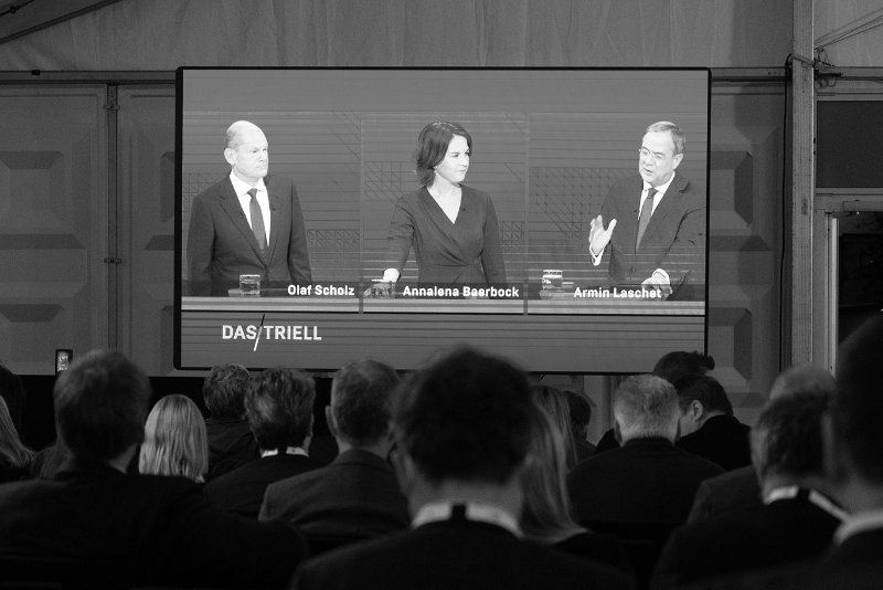 A l'écran, lors du débat, les candidats Olaf Scholz (SPD), Annalena Baerbock (Bündnis90/Die Grünen) et Armin Laschet, (CDU).